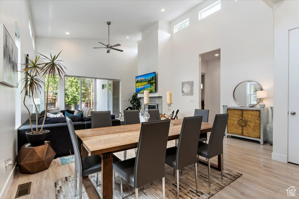 Dining space featuring light wood-type flooring, ceiling fan, and high vaulted ceiling