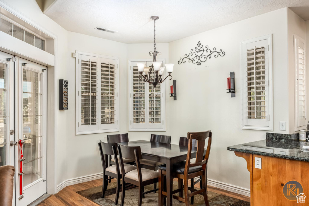 Dining space with a chandelier and dark hardwood / wood-style flooring