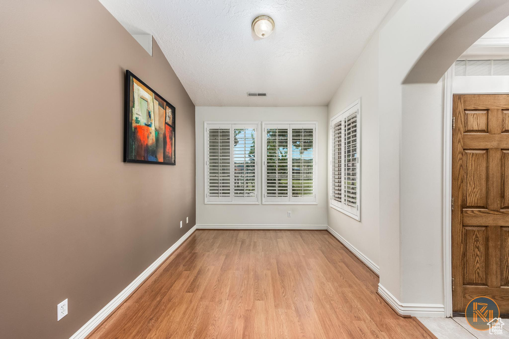 Spare room with light hardwood / wood-style floors and a textured ceiling