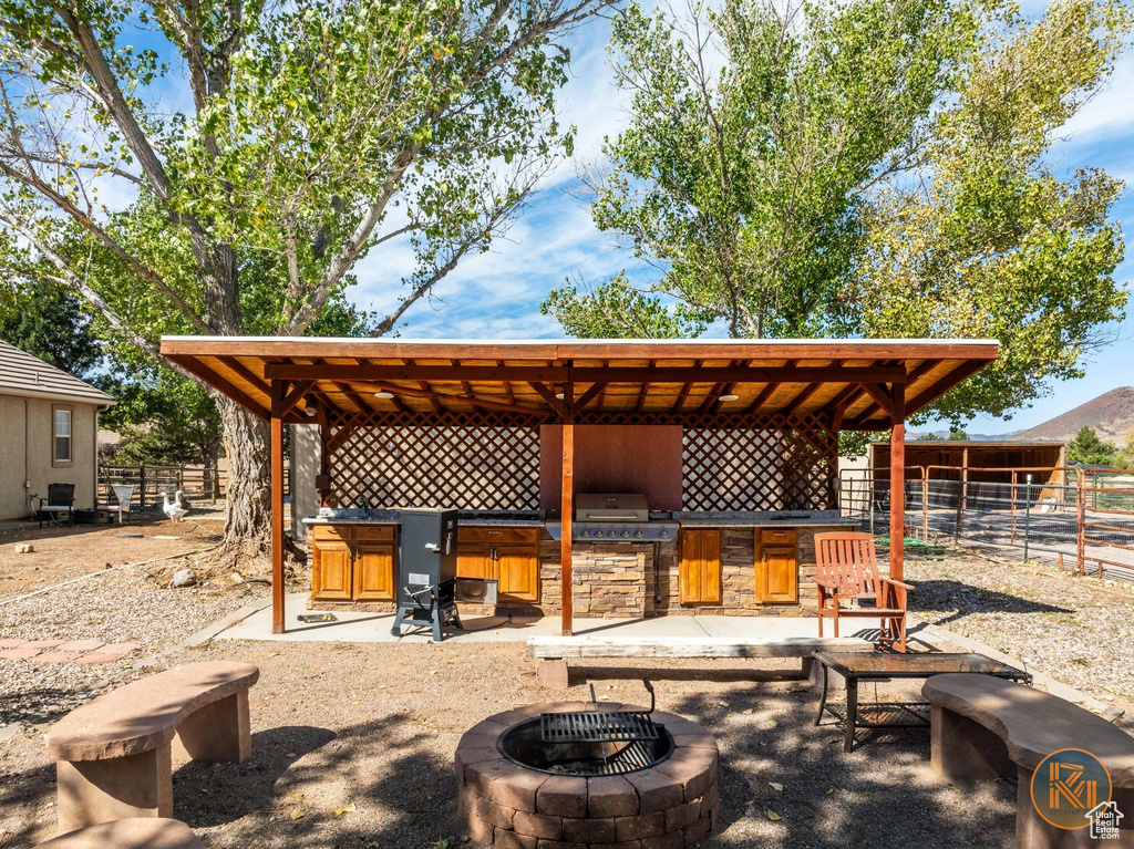 View of patio with grilling area and an outdoor fire pit