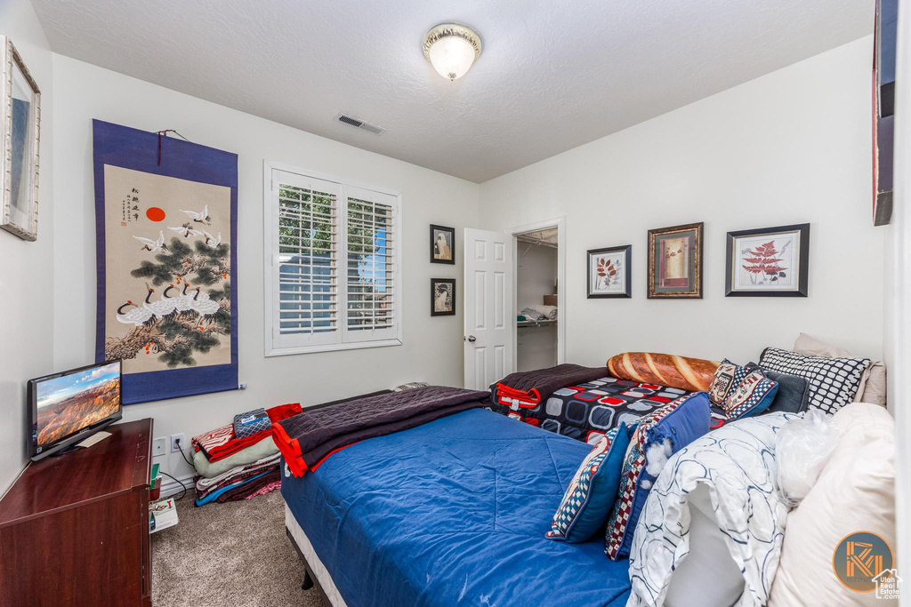 Bedroom with a textured ceiling and carpet