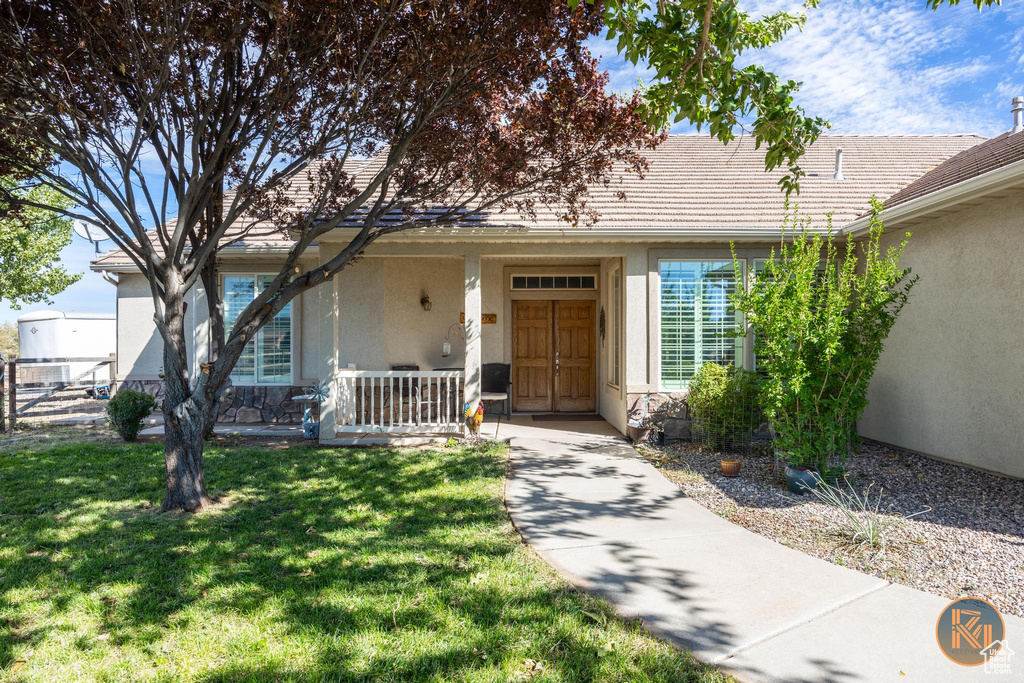 Property entrance with a lawn and a porch