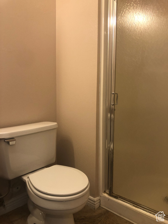 Bathroom featuring toilet and an enclosed shower