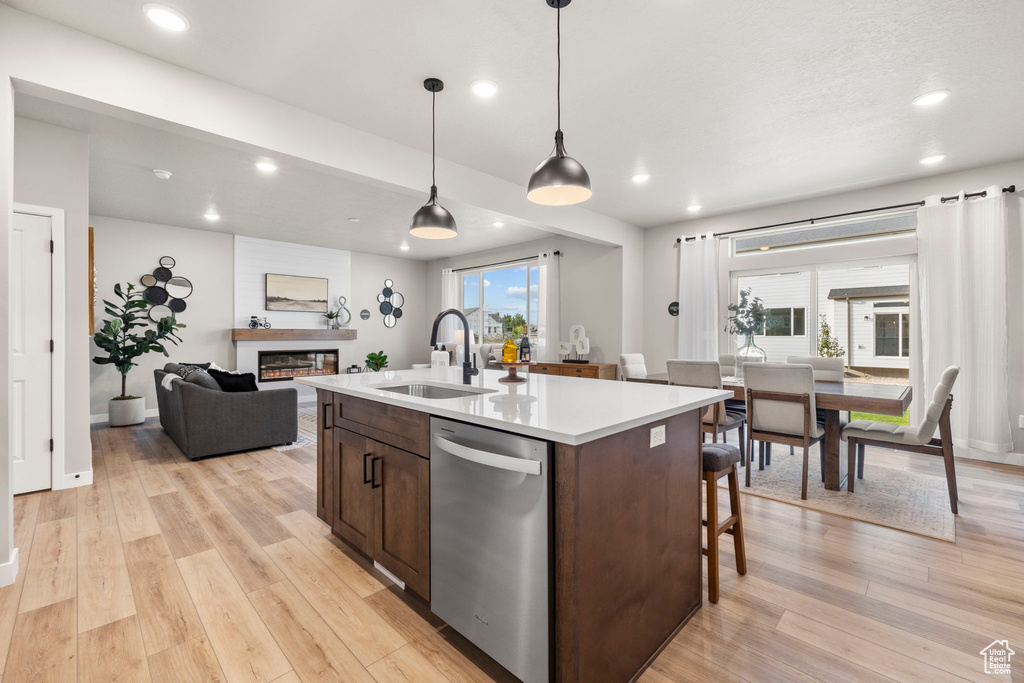 Kitchen with an island with sink, a large fireplace, plenty of natural light, and stainless steel dishwasher