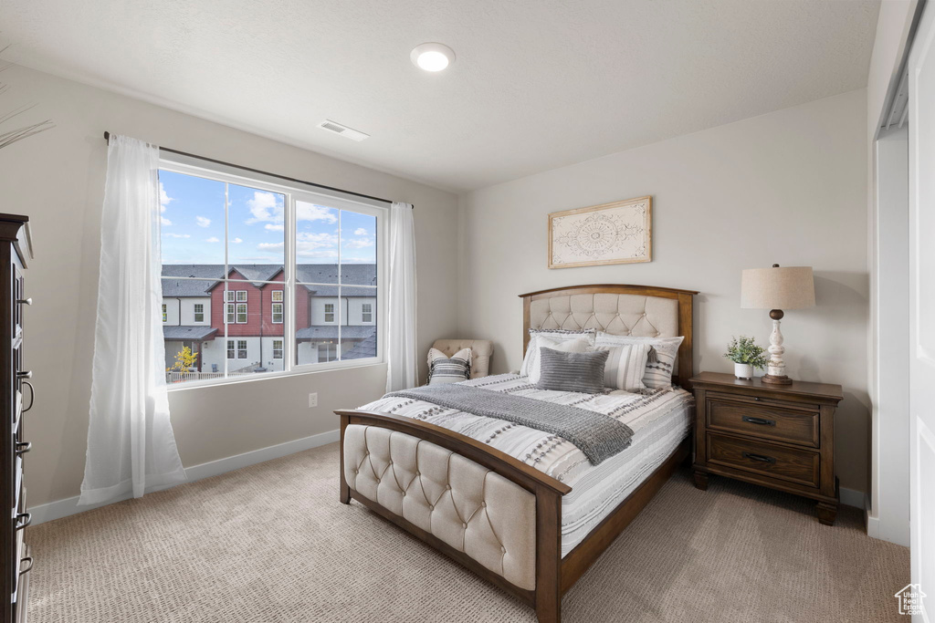 Bedroom featuring light carpet