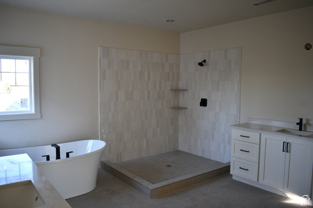 Bathroom with vanity, tile patterned flooring, and shower with separate bathtub