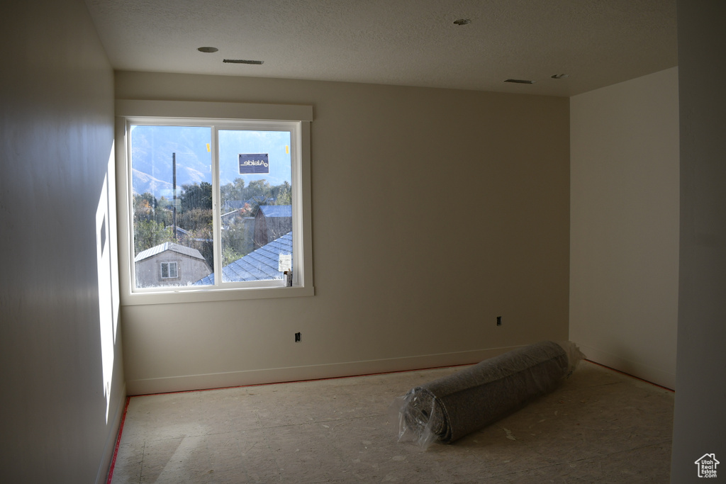 Unfurnished room featuring a textured ceiling