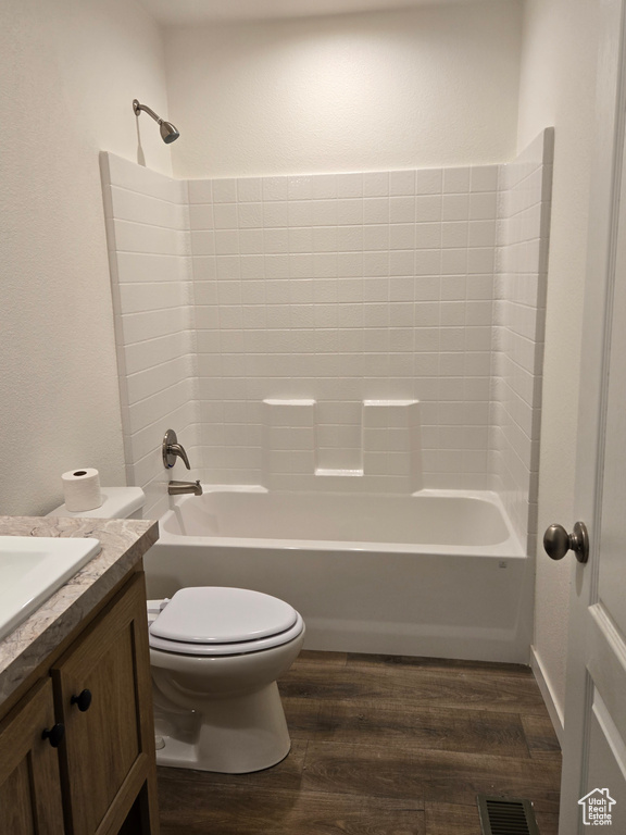 Full bathroom with wood-type flooring, shower / tub combination, and toilet