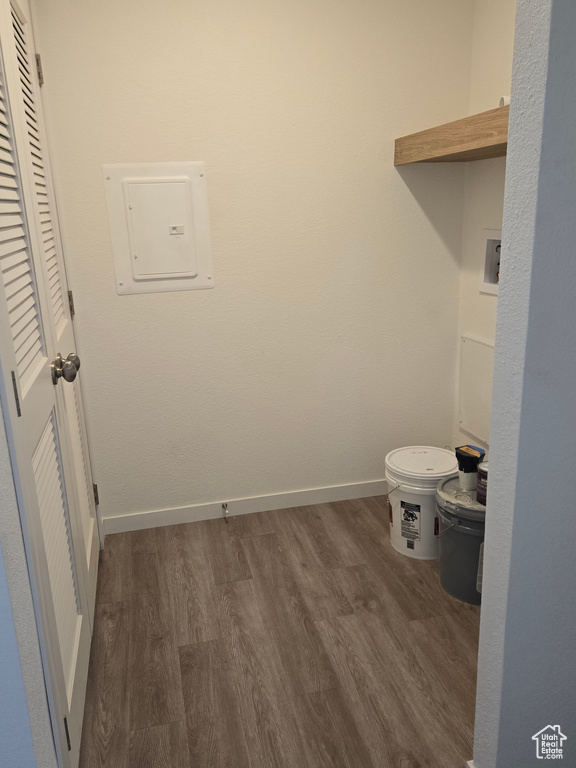 Laundry area with electric panel and dark hardwood / wood-style floors