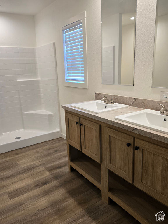 Bathroom featuring wood-type flooring, vanity, and walk in shower