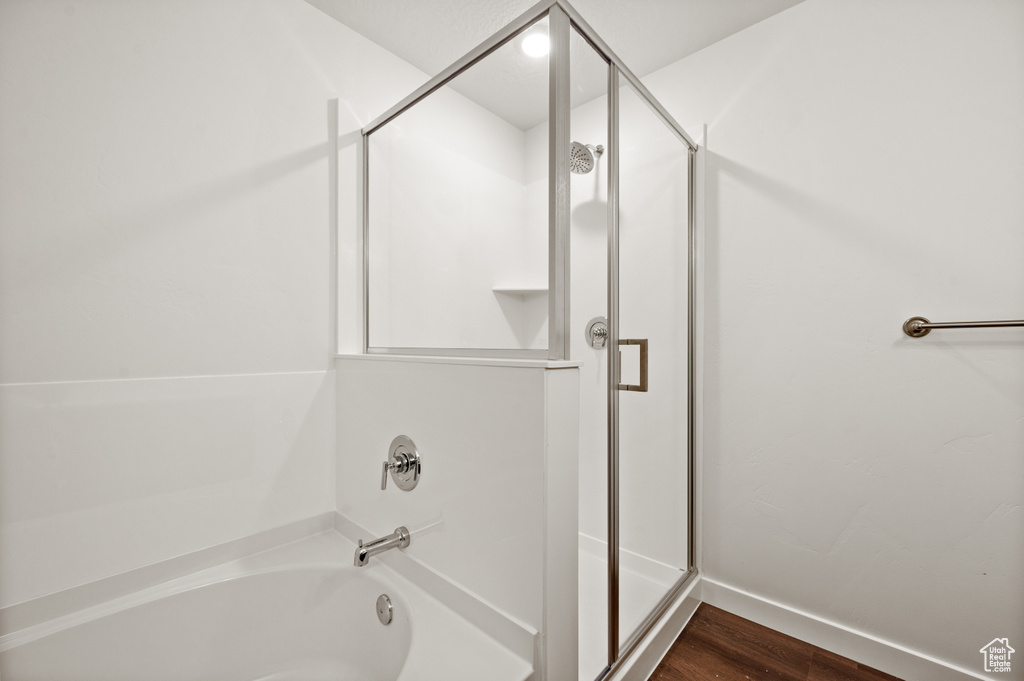 Bathroom featuring hardwood / wood-style floors and separate shower and tub