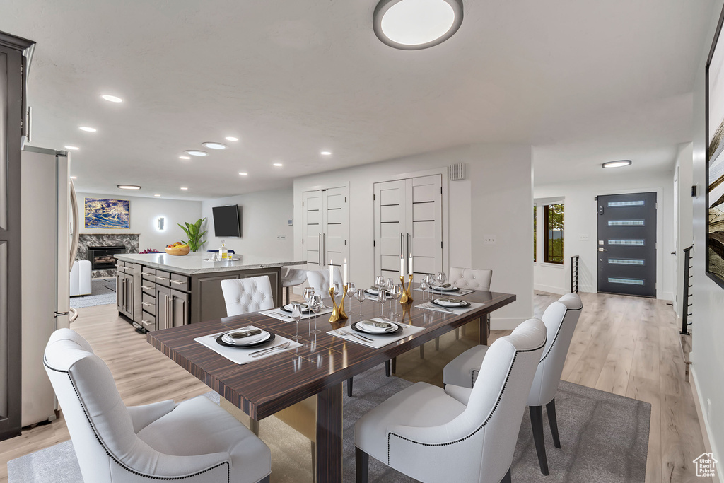 Dining room with light hardwood / wood-style flooring and a fireplace