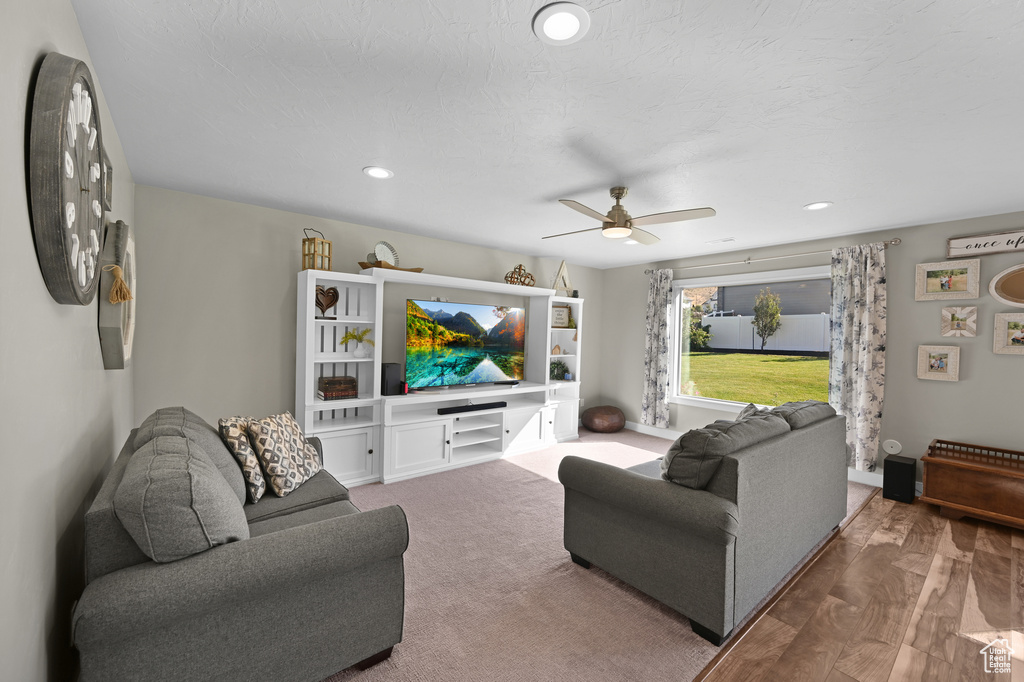 Living room with ceiling fan and hardwood / wood-style flooring