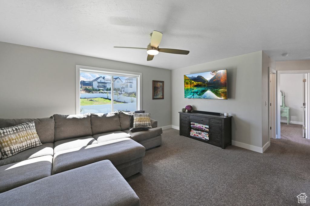 Carpeted living room featuring ceiling fan