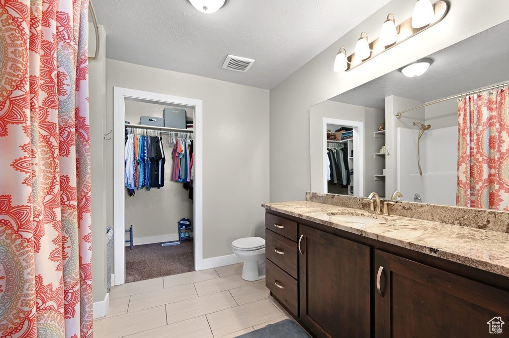 Bathroom featuring a shower with curtain, a textured ceiling, vanity, and toilet