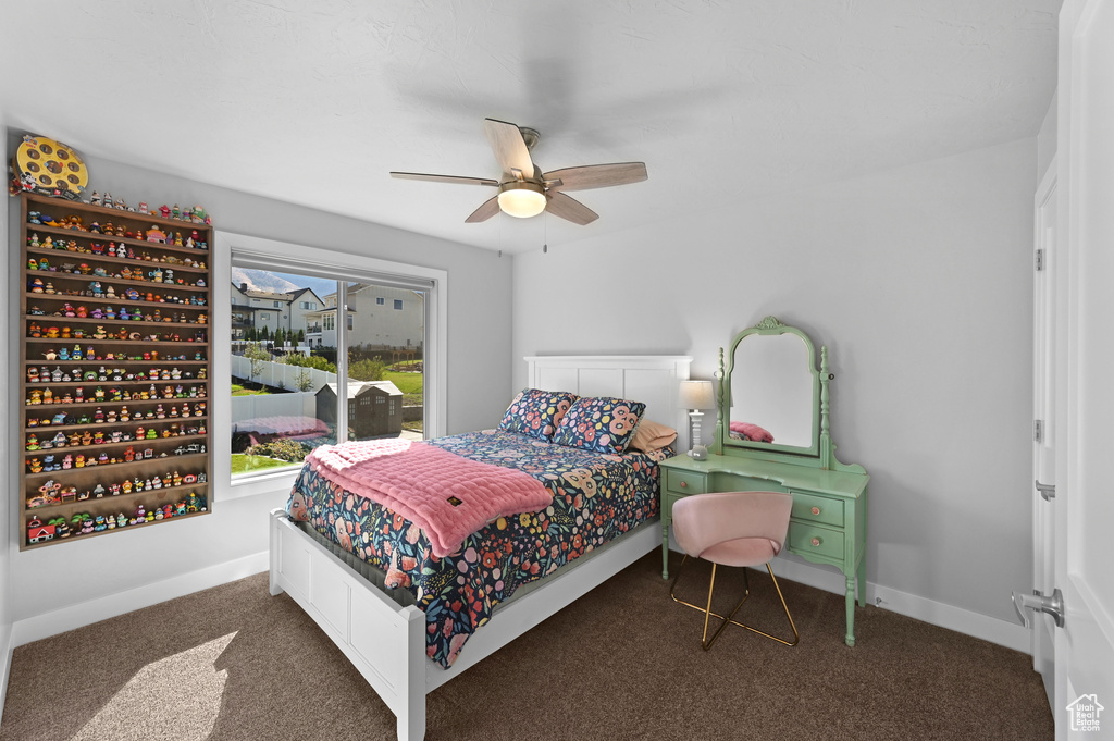 Carpeted bedroom featuring ceiling fan