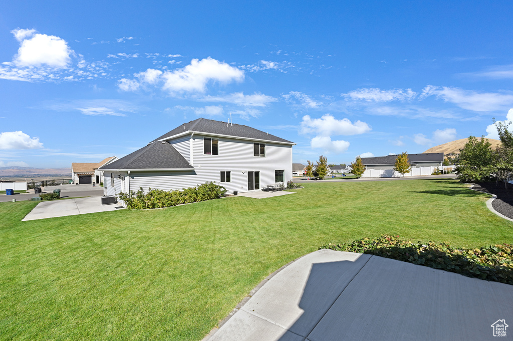 Back of property with a lawn and a patio