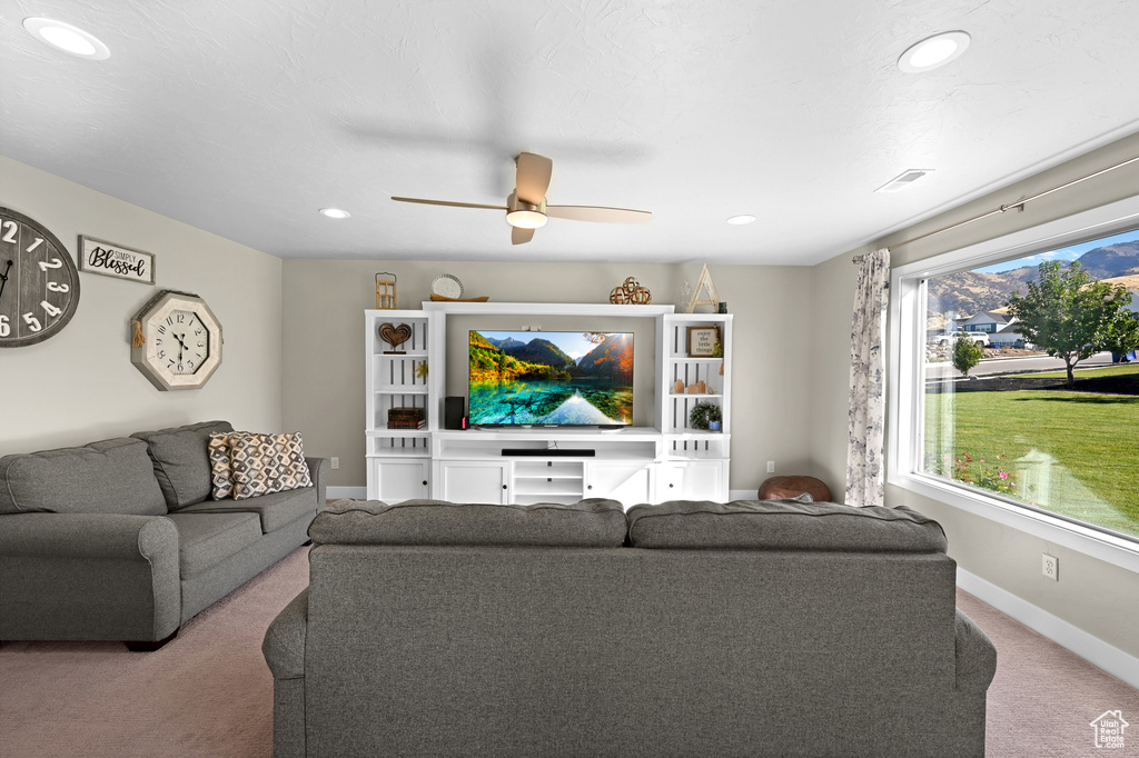 Carpeted living room with ceiling fan