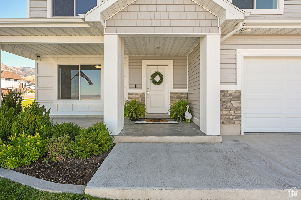 View of exterior entry with covered porch and a garage