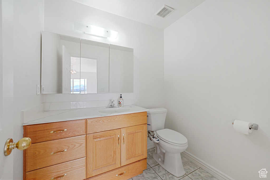 Bathroom with vanity, toilet, and tile patterned floors