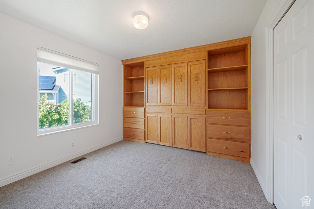 Unfurnished bedroom with light colored carpet and a closet