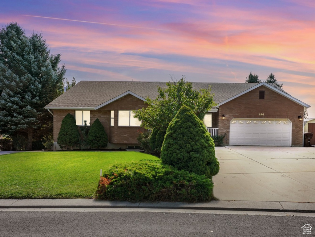 View of front of home featuring a garage and a lawn