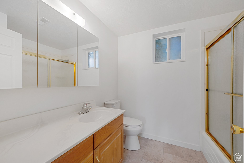 Full bathroom with combined bath / shower with glass door, vanity, and toilet