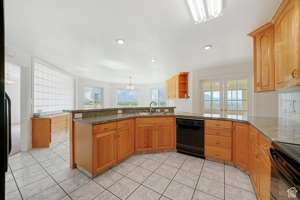 Kitchen with a healthy amount of sunlight, kitchen peninsula, dishwasher, and sink