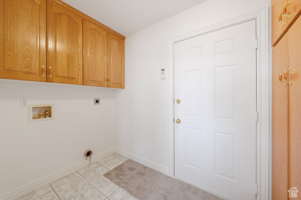 Laundry room with cabinets, hookup for an electric dryer, washer hookup, and light tile patterned flooring