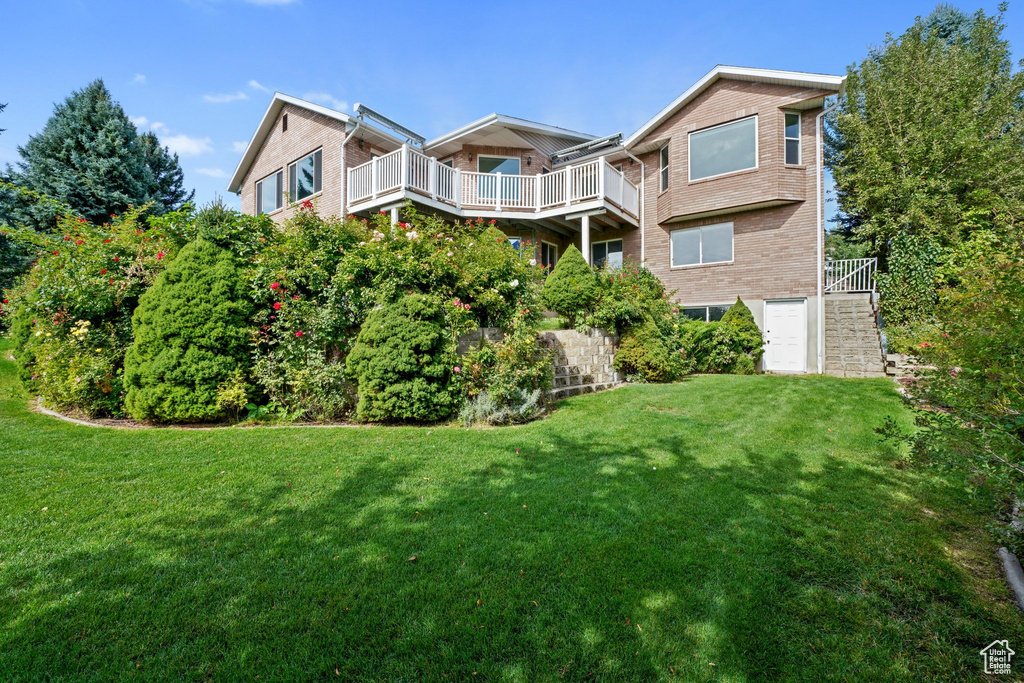 Exterior space featuring a yard and a balcony