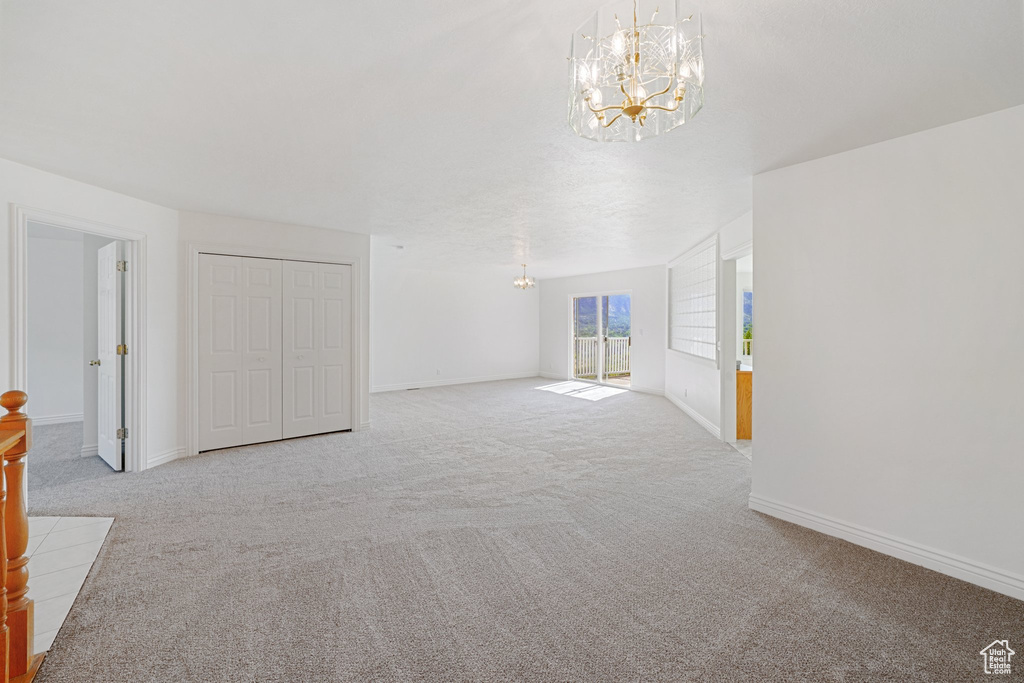 Interior space featuring light carpet and a notable chandelier