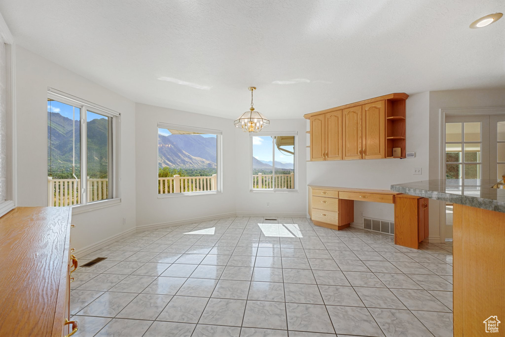 Kitchen featuring a mountain view, decorative light fixtures, a chandelier, and light tile patterned floors