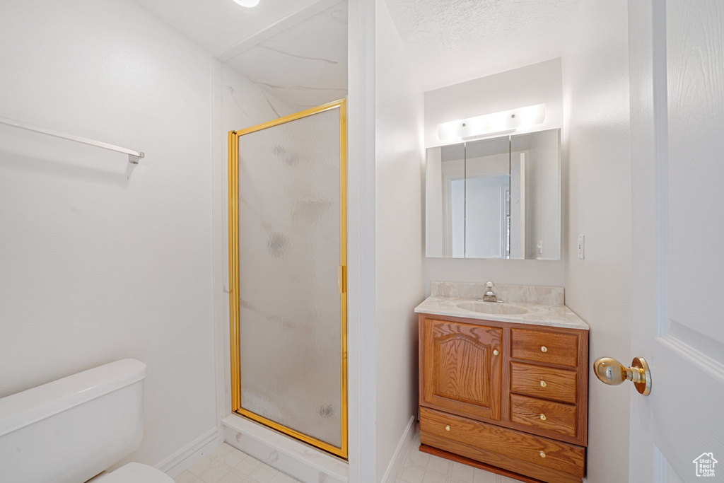 Bathroom with a shower with door, toilet, and vanity