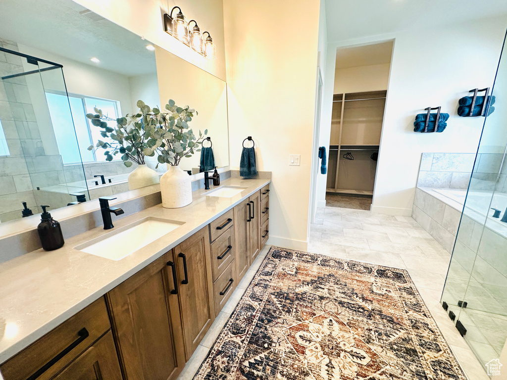 Bathroom featuring shower with separate bathtub, tile patterned flooring, and vanity