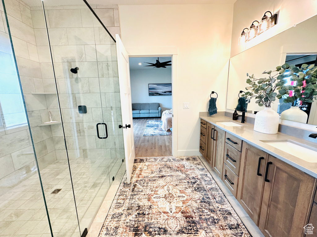 Bathroom with a shower with door, ceiling fan, hardwood / wood-style flooring, and vanity