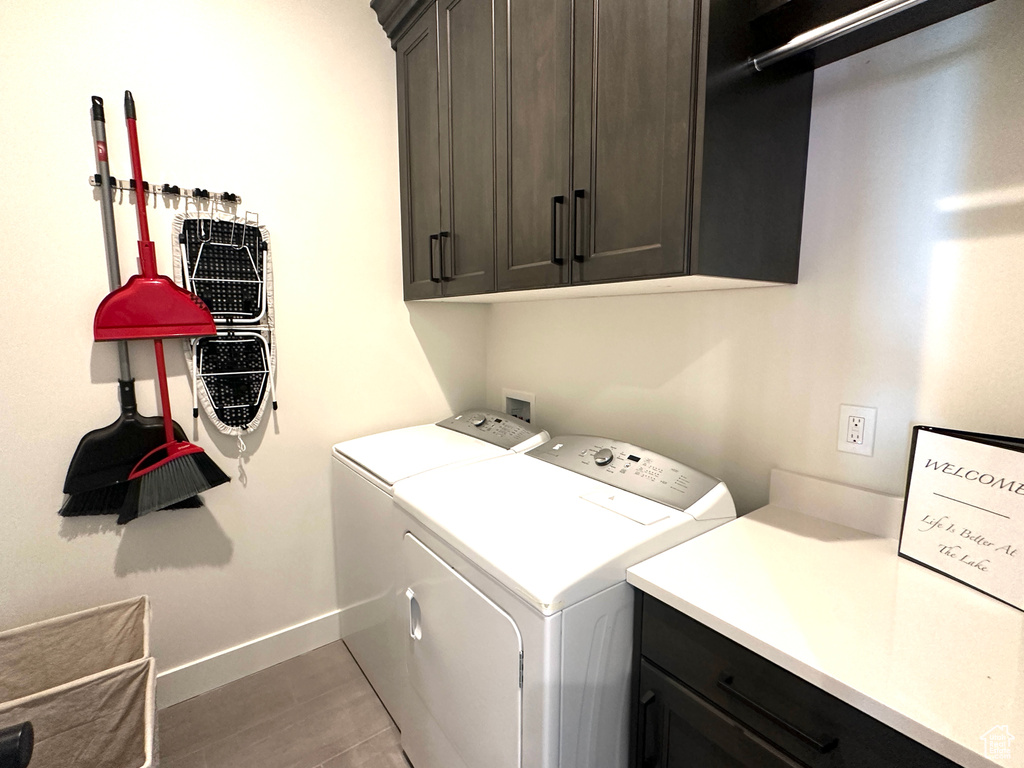 Laundry area featuring cabinets, tile patterned flooring, and washer and dryer