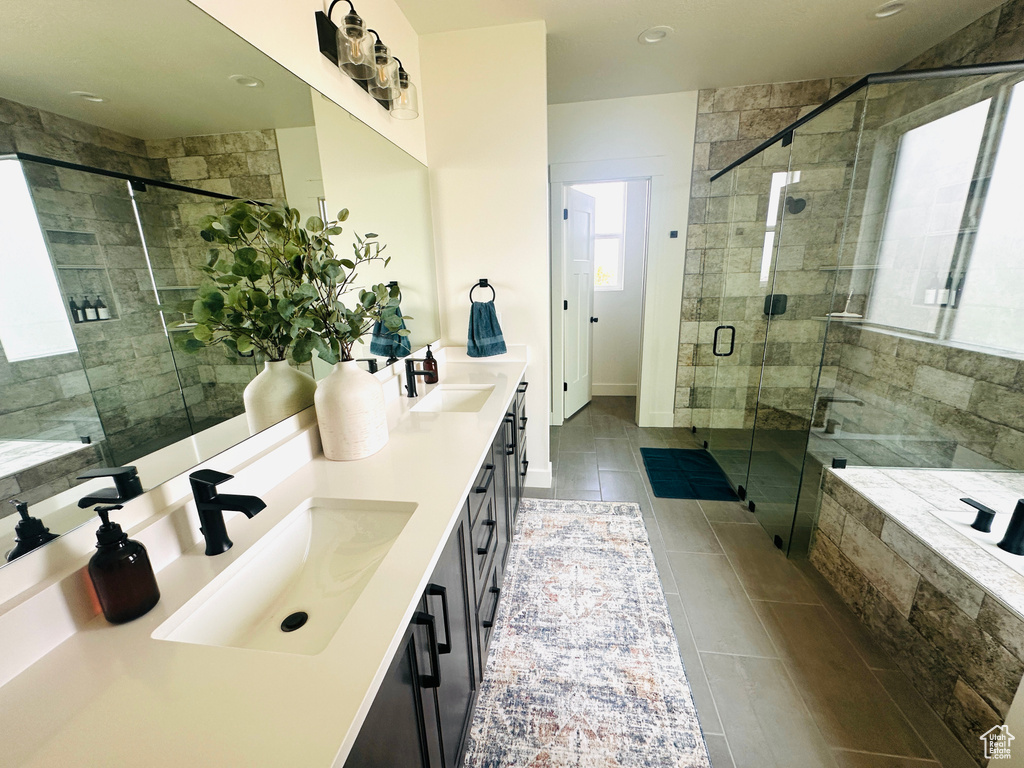 Bathroom featuring tile patterned floors, a shower with shower door, and vanity