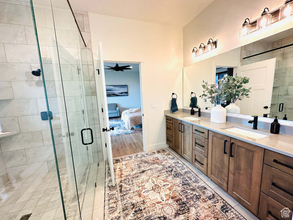 Bathroom with hardwood / wood-style floors, ceiling fan, walk in shower, and vanity