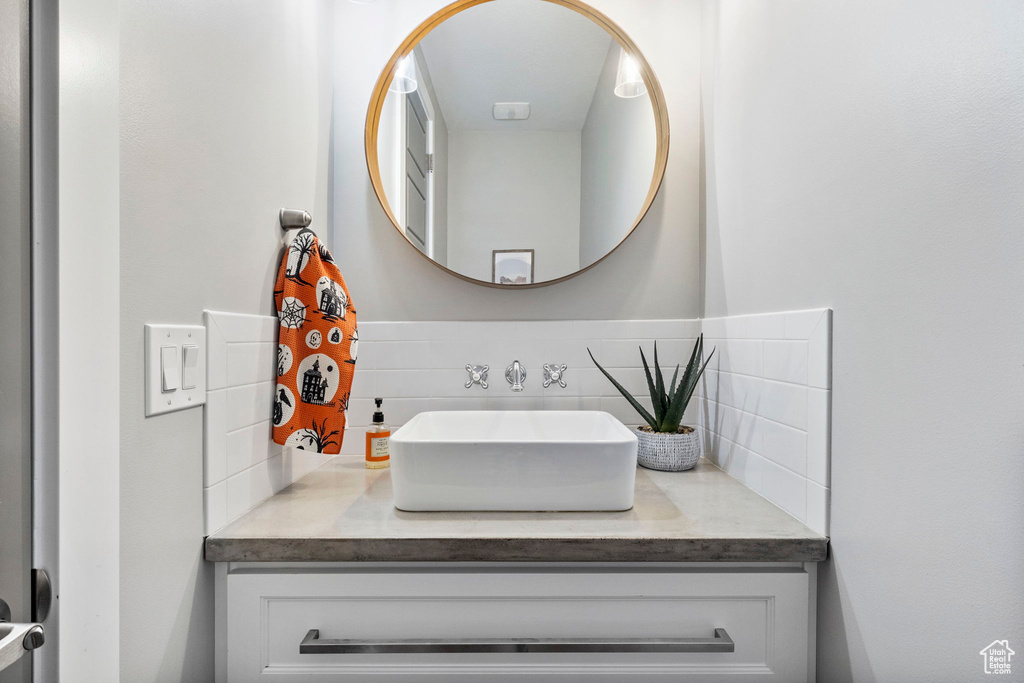 Bathroom featuring vanity and tasteful backsplash