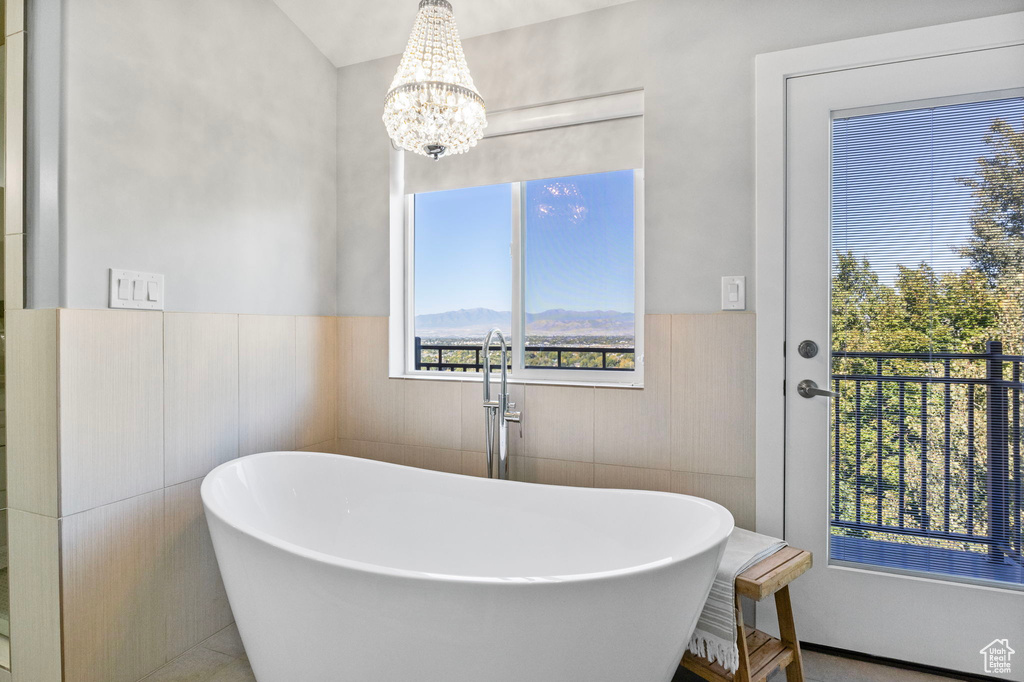 Bathroom featuring a mountain view, tile walls, sink, and a washtub