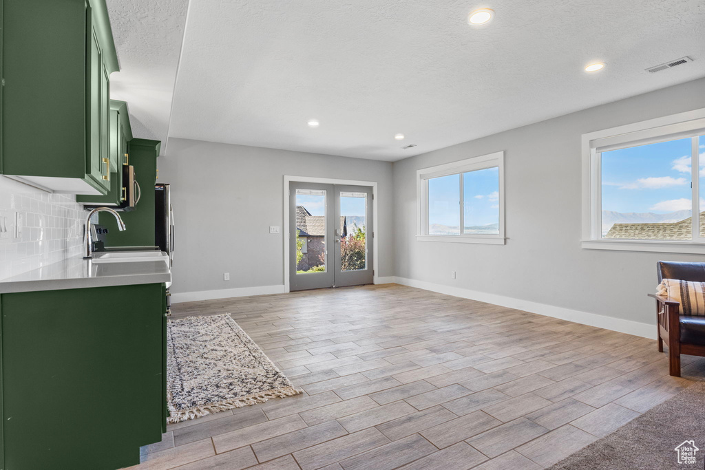 Living room featuring a textured ceiling, light wood-type flooring, and sink