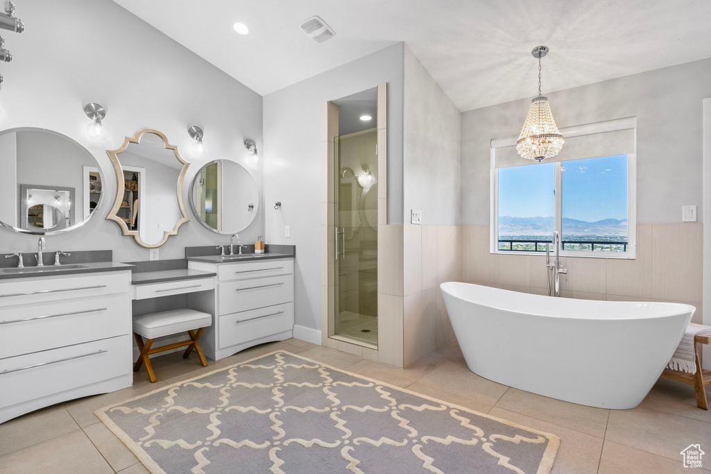 Bathroom featuring a notable chandelier, tile patterned floors, independent shower and bath, and vanity