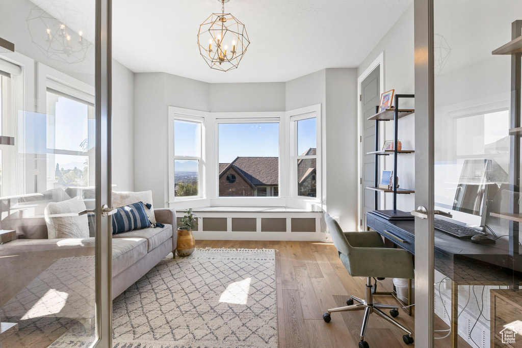 Office space featuring an inviting chandelier and light wood-type flooring