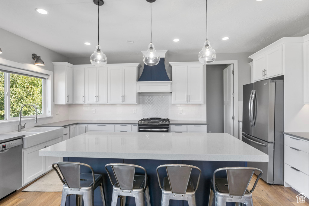 Kitchen with appliances with stainless steel finishes, a center island, and white cabinets