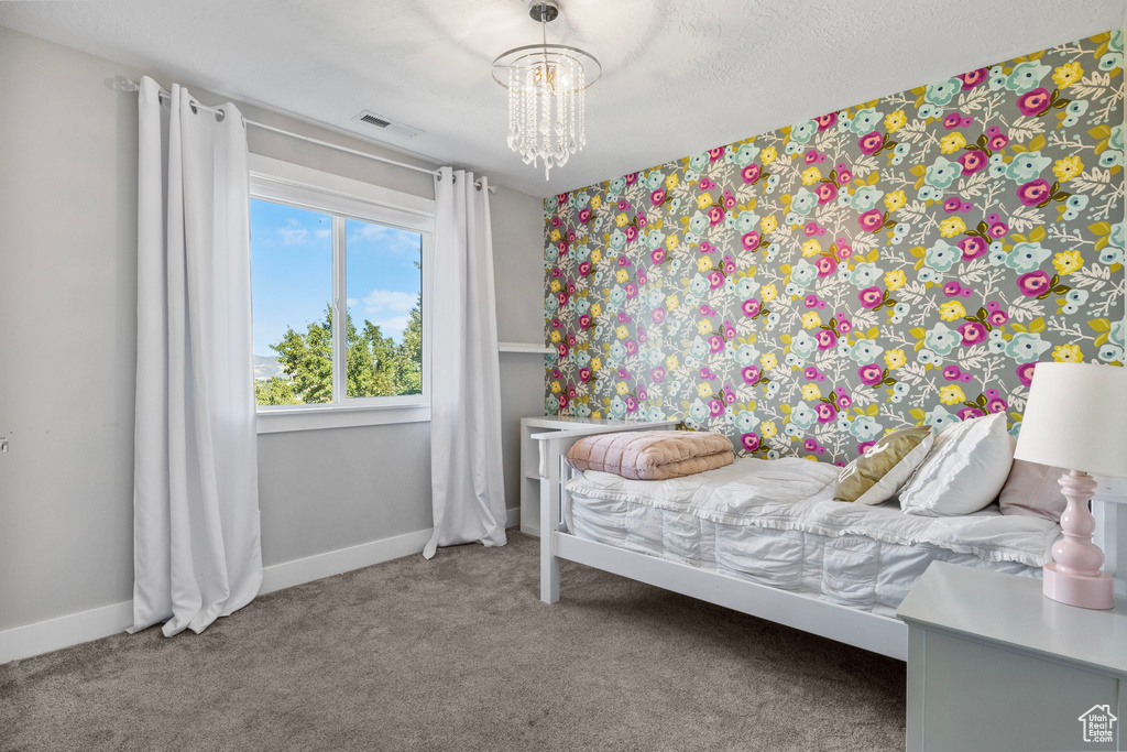 Bedroom featuring carpet and a notable chandelier