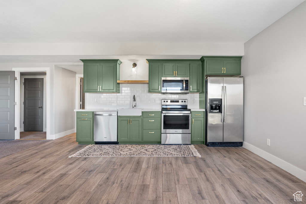 Kitchen featuring green cabinets, appliances with stainless steel finishes, and sink