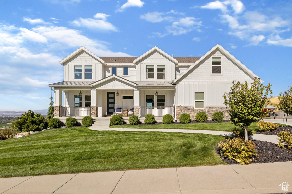 View of front of home with a front yard and covered porch