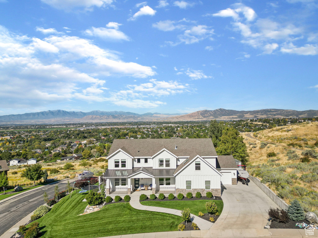 Exterior space with a front lawn, a mountain view, and covered porch