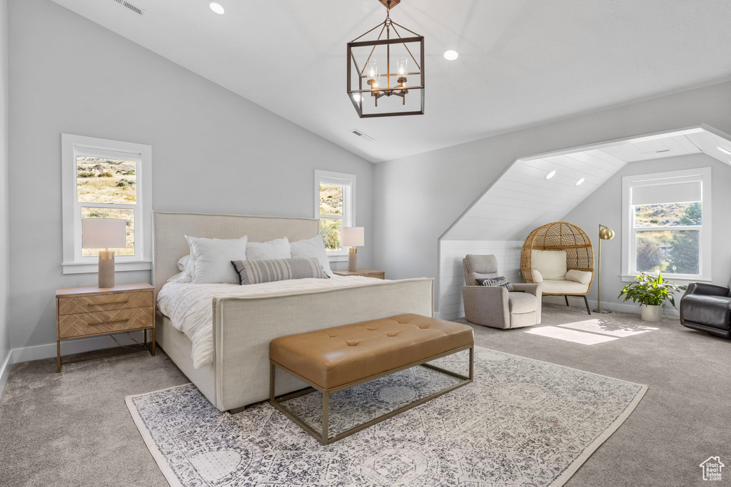 Carpeted bedroom featuring a notable chandelier, vaulted ceiling, and multiple windows