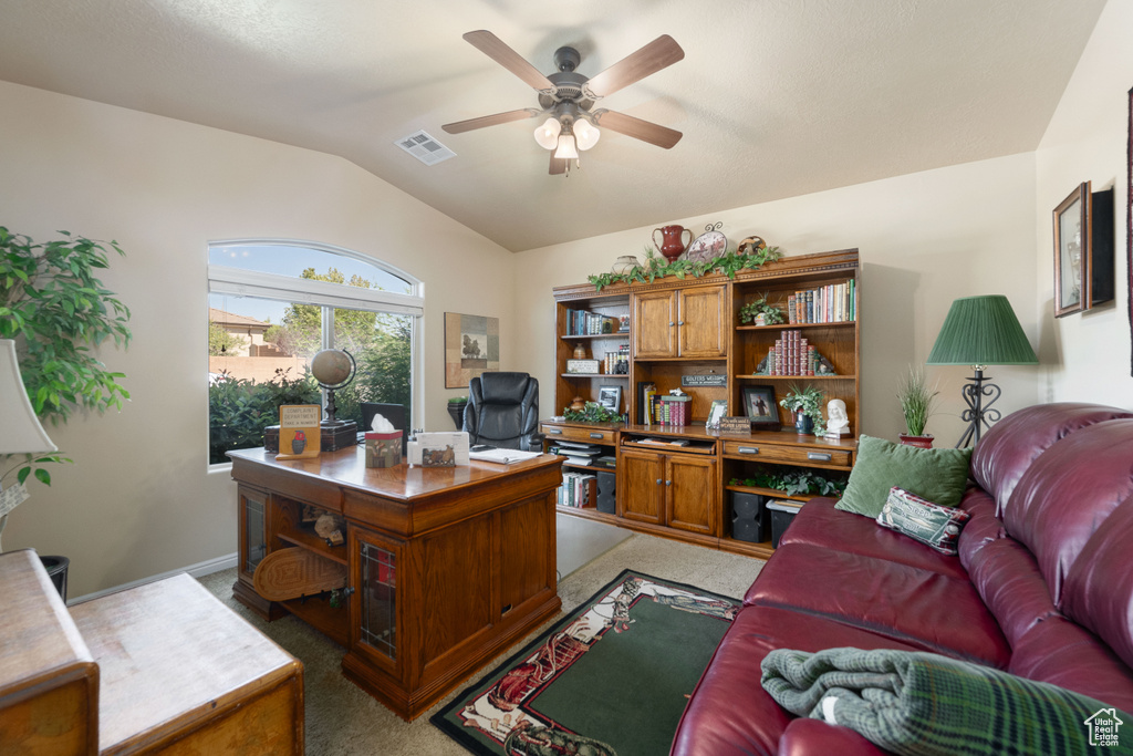 Carpeted home office with lofted ceiling and ceiling fan